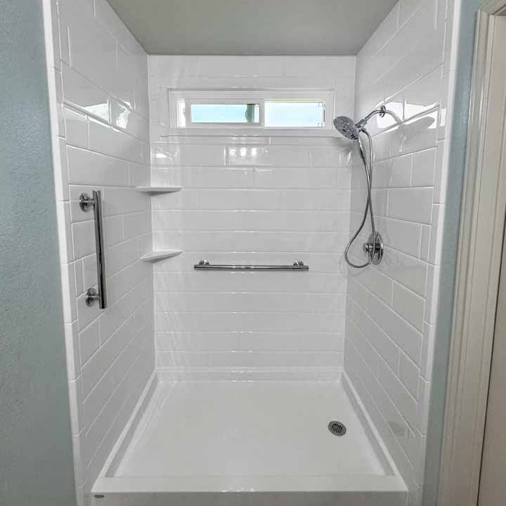 After - clean white tile walk-in shower